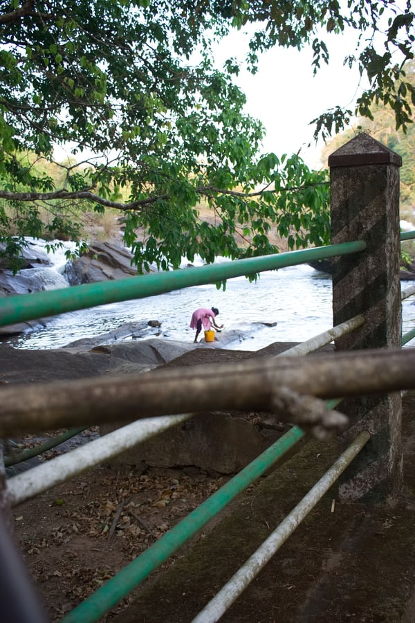 Woman washing clothes in the water, somewhere around Vazhachal Falls Ernakulam, Kerala, India