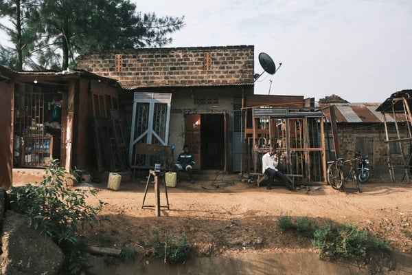 People hanging out in front of homes, Uganda