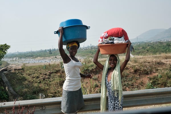 Kids carrying laundry baskets on their heads, Uganda