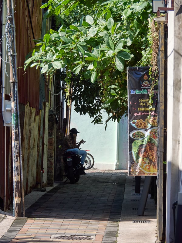 Look through allyway, hand gestures, strong light and shadows, Penang, Malaysia